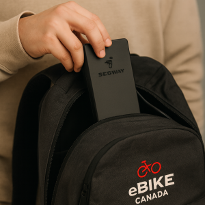 Commuter placing Segway Ninebot electric scooter charger into Ebike Canada branded backpack – portable and travel-friendly accessory